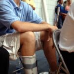 Jazz rookie Curtis Borchardt watches the Jazz v. Denber Nuggets' game with an injured foot. (Credit: Johanna Kirk, Deseret News)