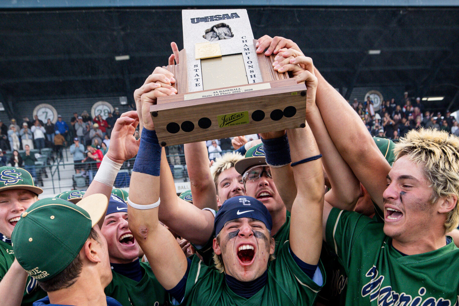 Snow Canyon’s Braden Mugavero, center, lifts the 4A baseball trophy after defeating Deseret Hills...