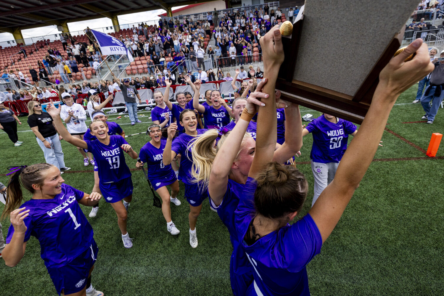 Riverton players celebrate around the championship trophy after defeating Skyridge in overtime duri...