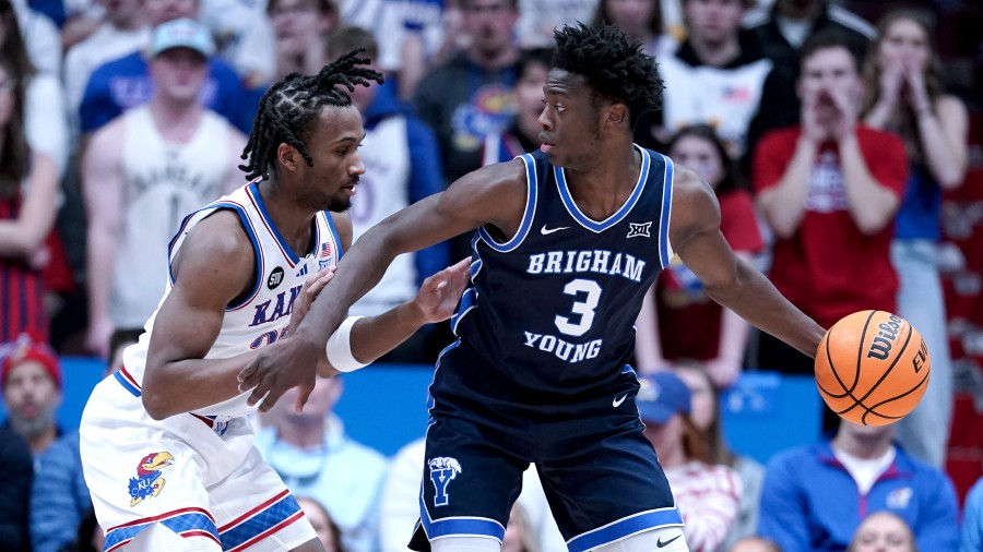 Forward AJ Dybantsa #3 of the BYU Cougars controls the ball as he is defended by guard Darryn Peter...