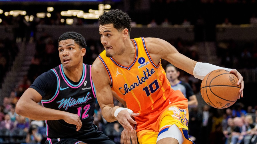 Josh Green #10 of the Charlotte Hornets goes to the basket while guarded by Dru Smith #12 of the Mi...