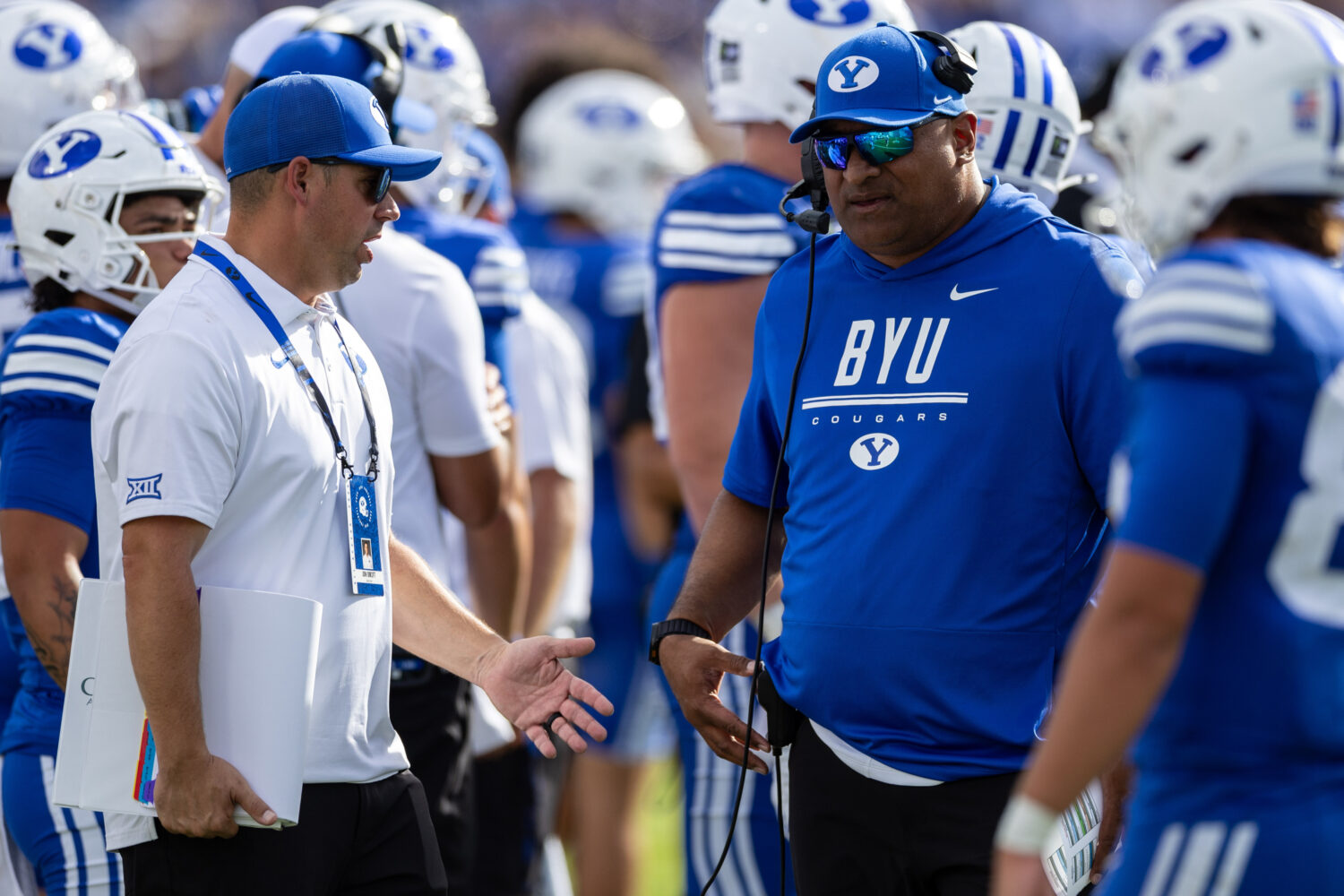 BYU Cougars head coach Kalani Sitake, right, speaks to one of his coaches during a football game ag...