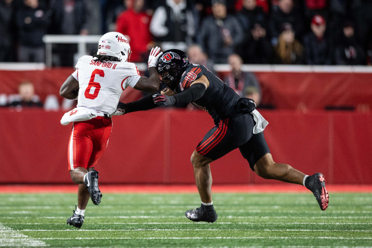 Houston Cougars running back Re'shaun Sanford II (6) tries to stiff arm a Utah defender during a ga...